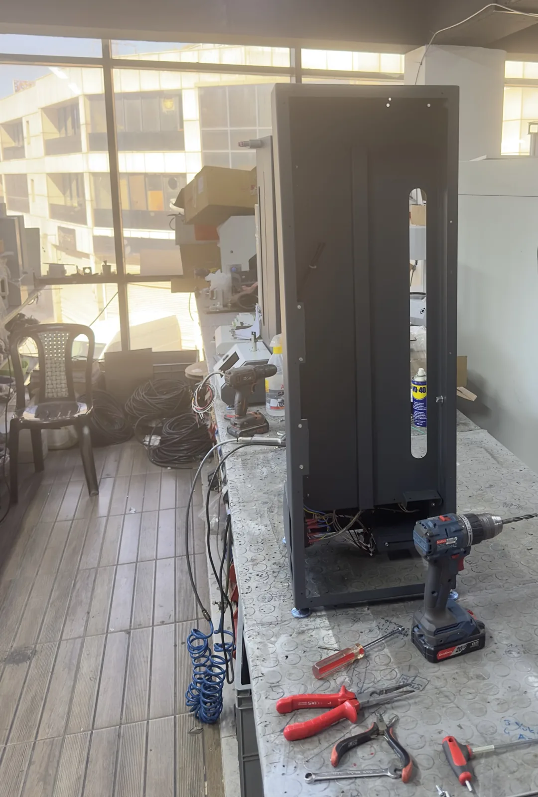 Sheet-metal instrument cabinet being assembled with hand tools